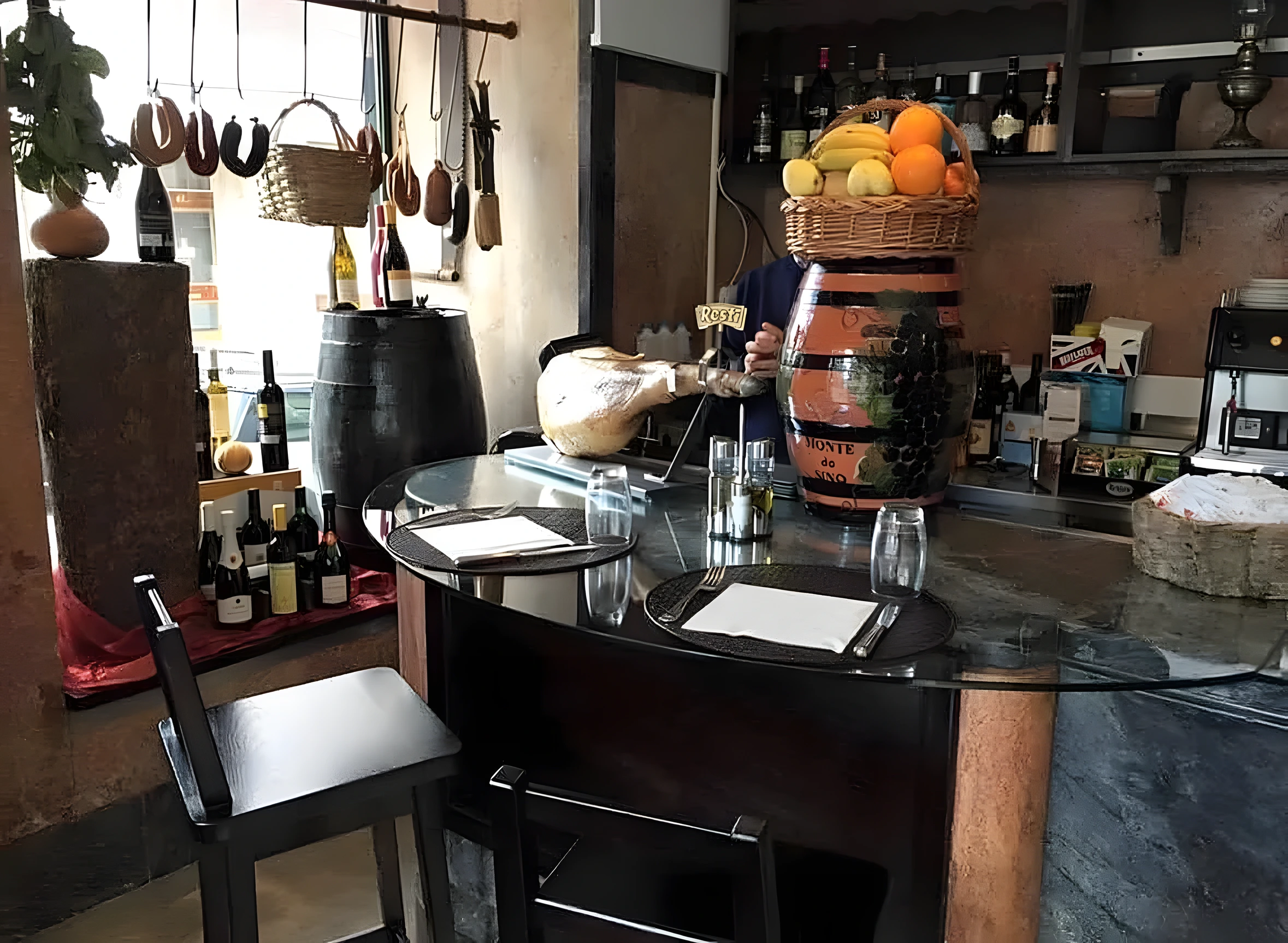 O balcão de mármore da Taberna dos Novos Tempos, com chouriços pendurados, presunto inteiro e barril de vinho pintado a fazer de fruteira.